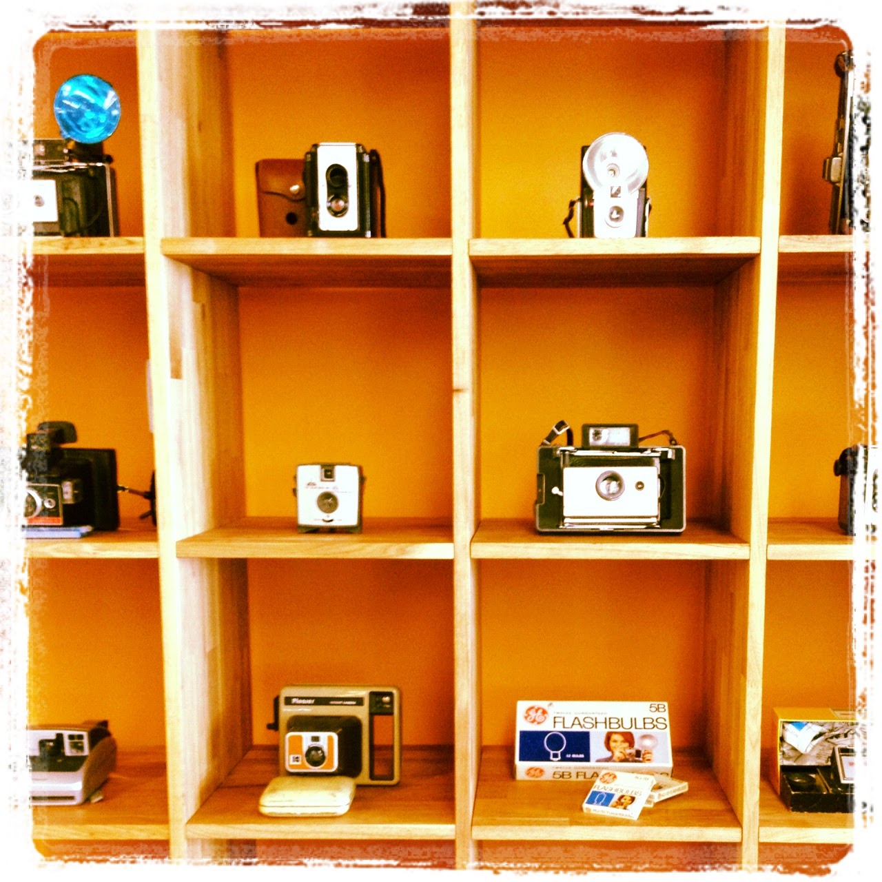 A collection of cameras on a shelf