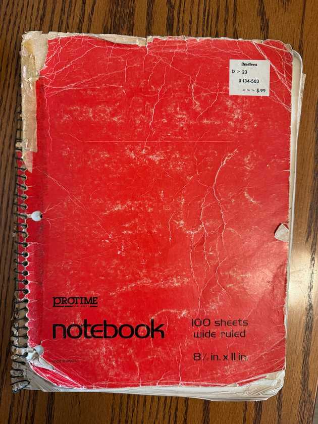 A red spiral-bound notebook.